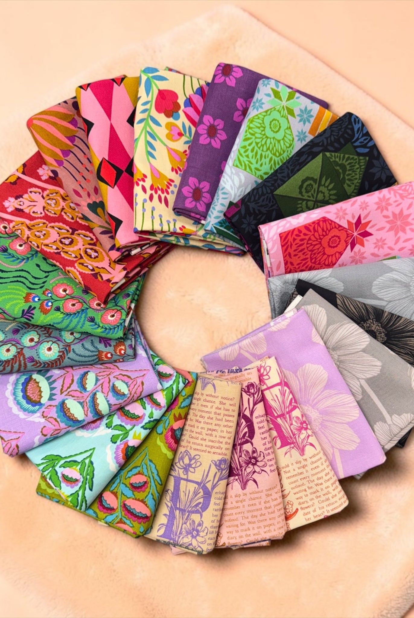 Collection of colorful fabric swatches arranged in a circular pattern on a wooden surface.