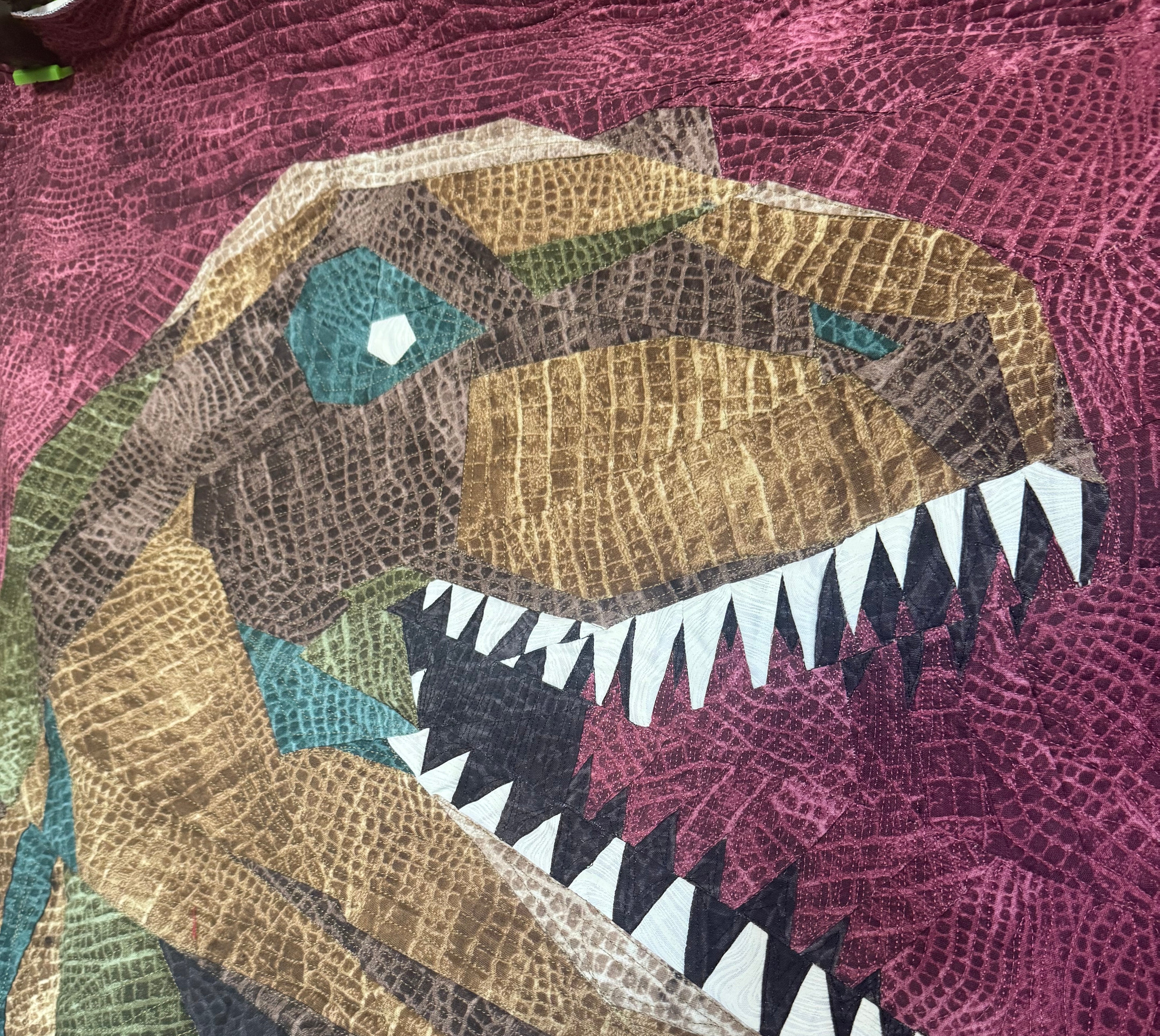 Quilt with a colorful dragon design on a purple background