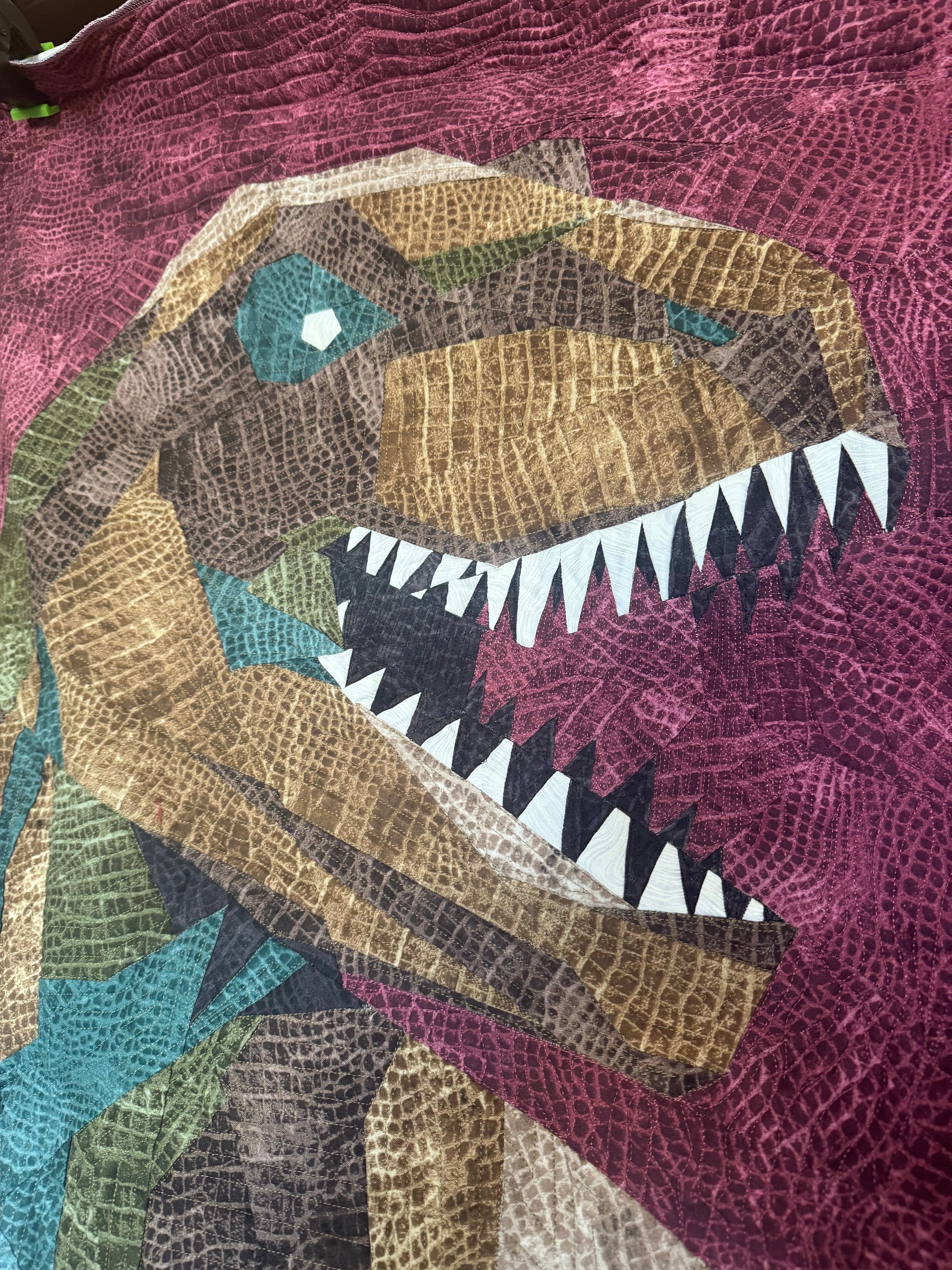 Quilt with a colorful dragon design on a purple background