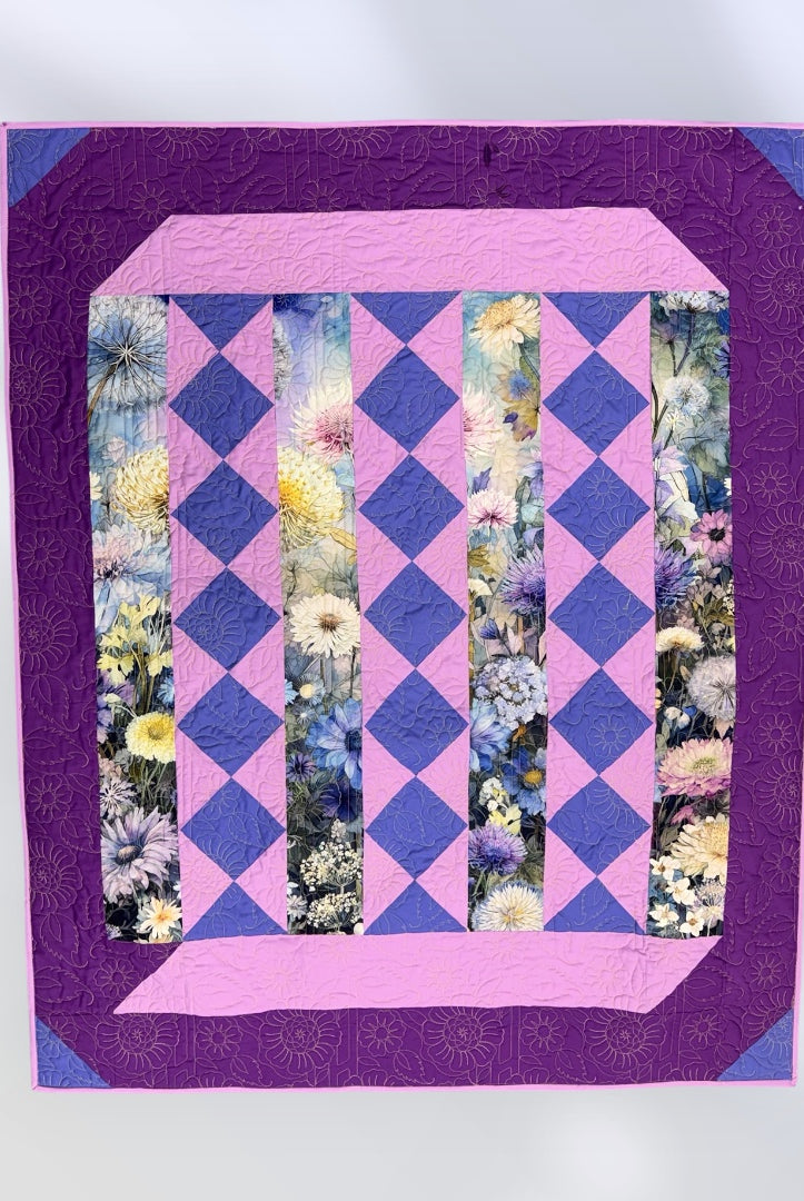 Quilt with purple and pink diamond pattern and floral inset on a white Lovely Flowers Quilt Kit Finished Size - Northcott/Timeless Treasures Fabric 49.75" x 60" -Carmons Quilt Shopbackground