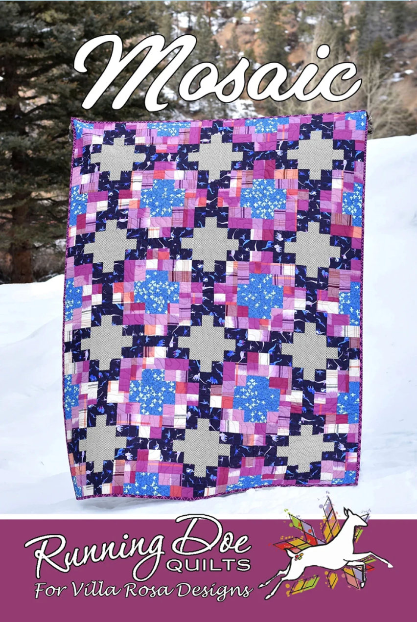 Quilt with mosaic pattern in front of a snowy landscape