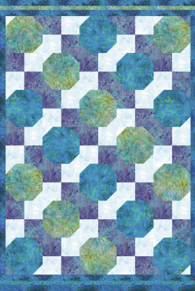 Quilt with blue and green circular patterns on a white background