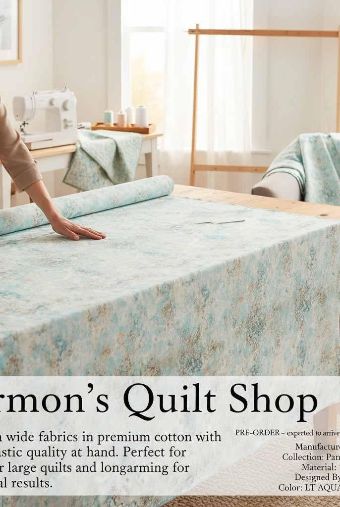 Carmon's Quilt Shop light aqua mottled texture 118 inch wide cotton quilting fabric draped over a wooden table