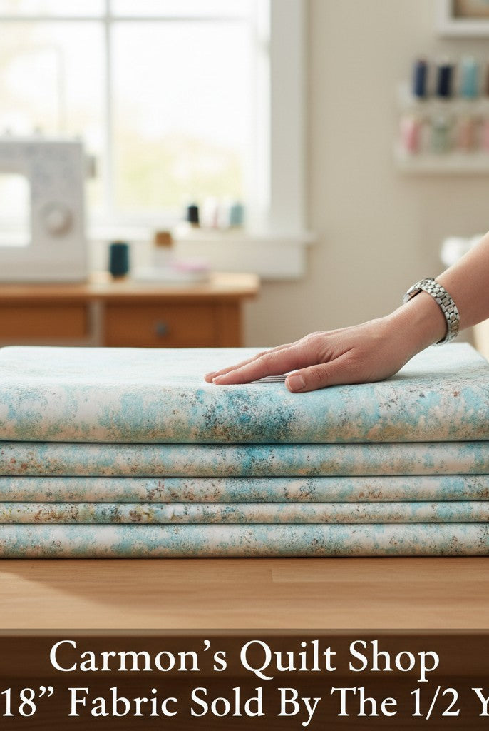Carmon's Quilt Shop light aqua mottled texture 118 inch wide cotton quilting fabric folded on a wooden table