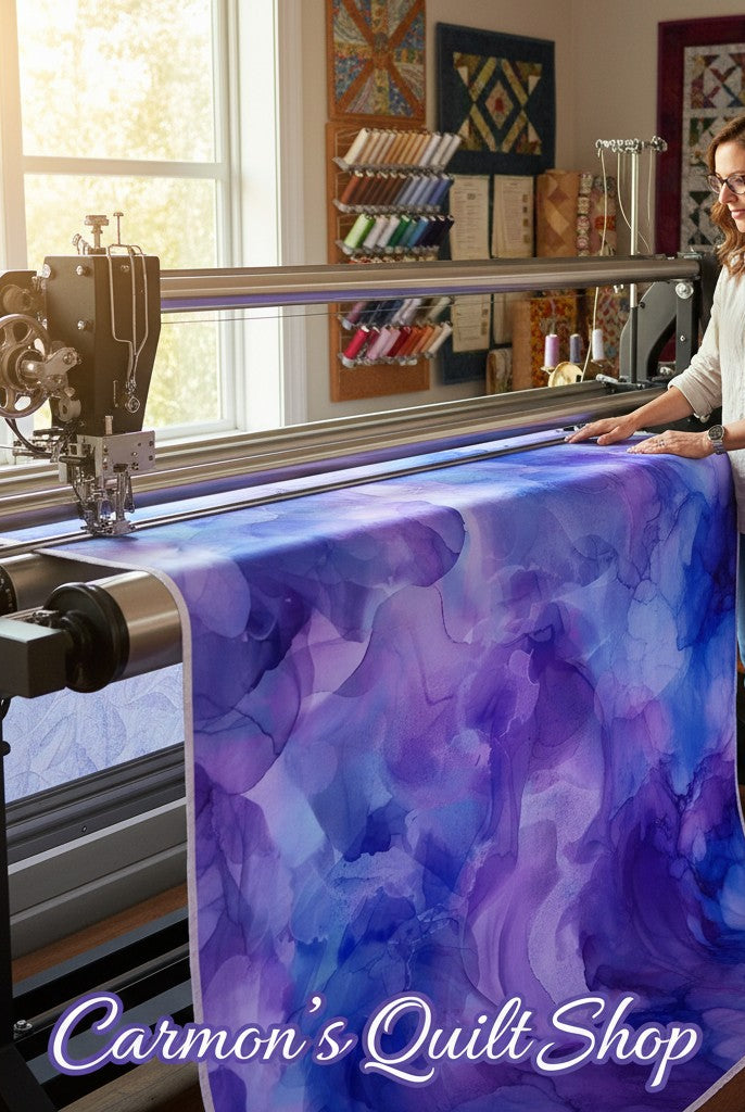 Carmon's Quilt Shop Aura Watercolor purple cotton fabric on a longarm quilting machine in a bright sewing studio.
