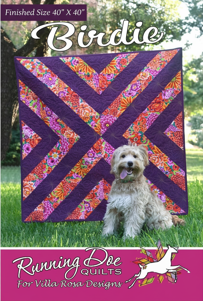 Carmon's Quilt Shop Birdie quilt pattern featuring a geometric purple and floral design with a dog sitting in front