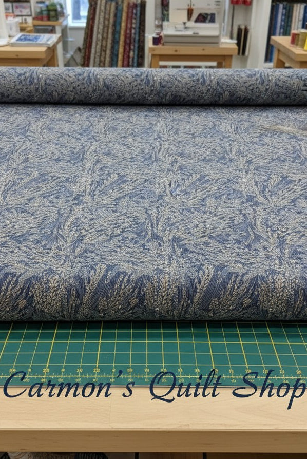 Carmon's Quilt Shop Meadow Breeze blue floral 108-inch wide cotton quilt backing fabric on a cutting mat.
