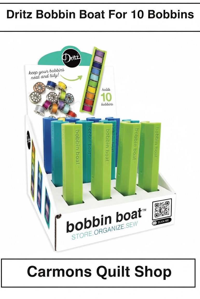 Carmon's Quilt Shop display box of green and blue Dritz Bobbin Boat organizers for sewing and quilting bobbins.