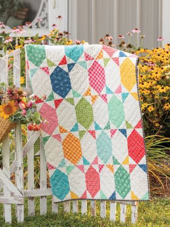 Carmon's Quilt Shop Forever Fabulous Fat Quarter quilt featuring colorful geometric patterns in a garden setting
