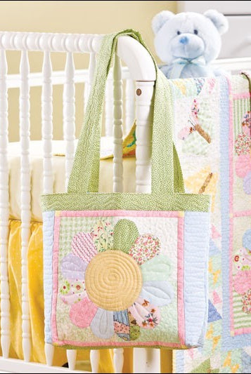 Carmon's Quilt Shop floral patchwork tote bag with pastel fabric scraps hanging on a baby crib