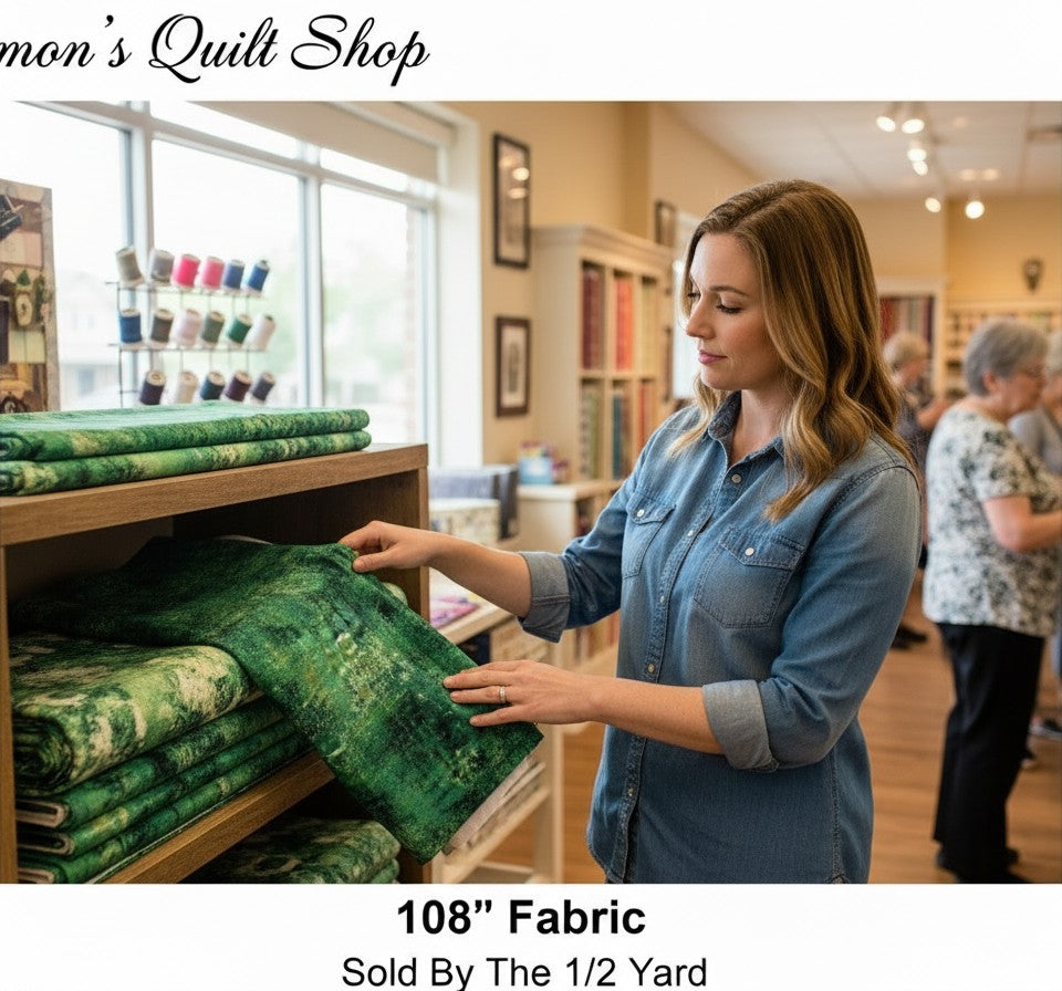 Carmon's Quilt Shop customer examining forest green mottled 108-inch wide QT Fabrics quilting cotton on a store shelf.