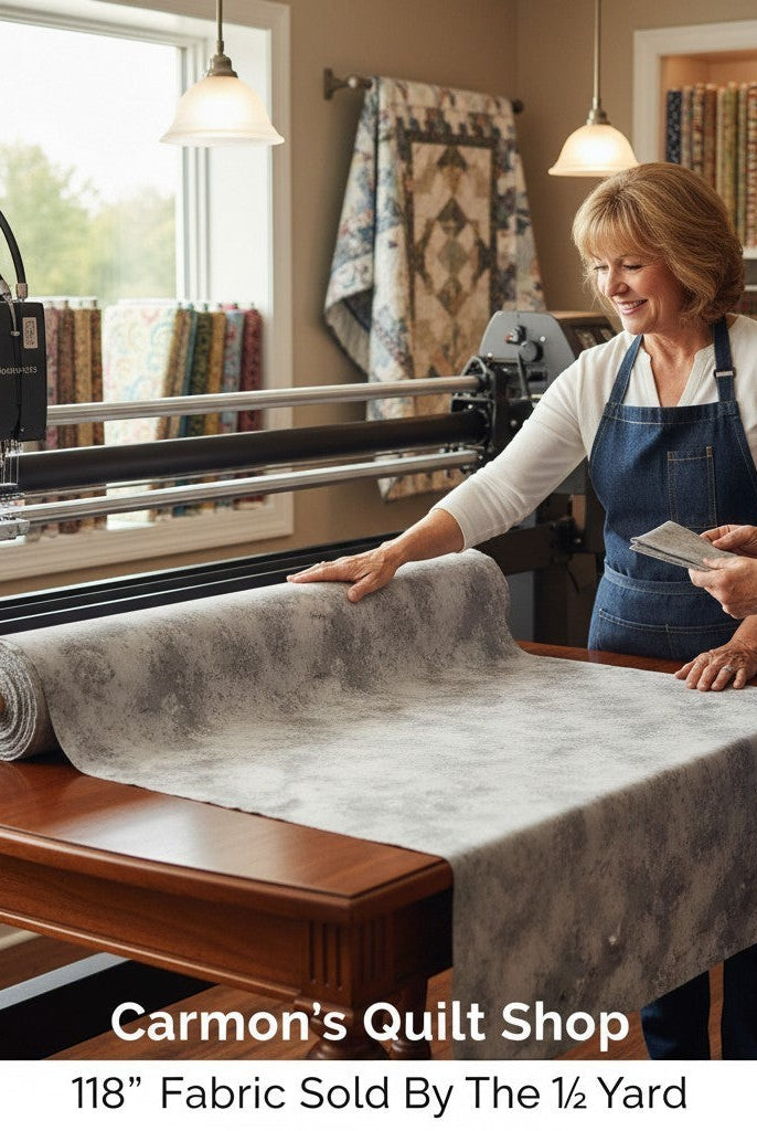Carmon's Quilt Shop 118-inch wide grey mottled cotton blender fabric being inspected by two women in a quilt studio.