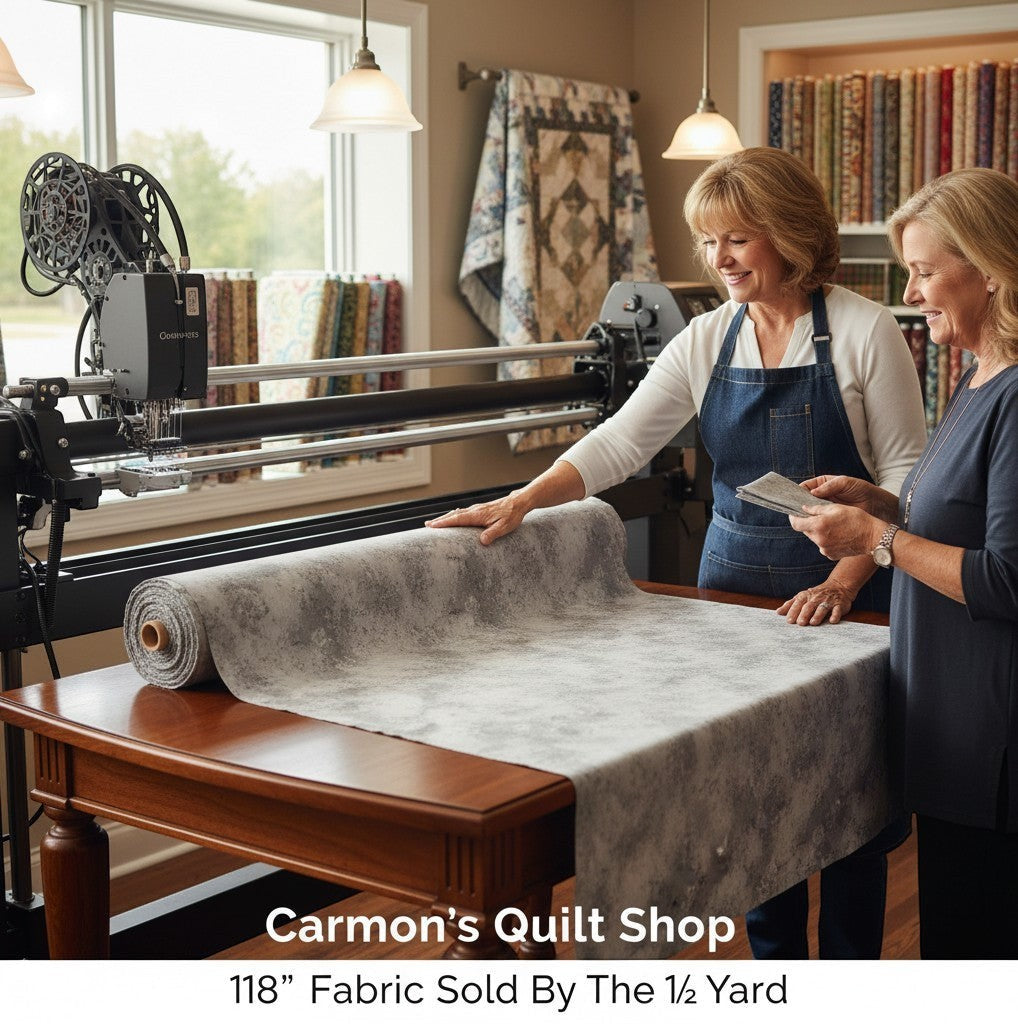 Carmon's Quilt Shop 118-inch wide grey mottled cotton blender fabric being inspected by two women in a quilt studio.