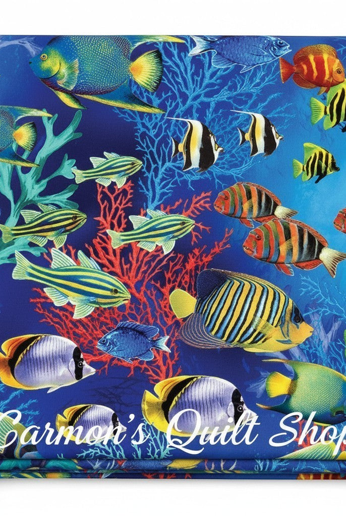 Carmon's Quilt Shop Jewel of The Sea cotton fabric featuring vibrant tropical fish and coral on a deep blue background