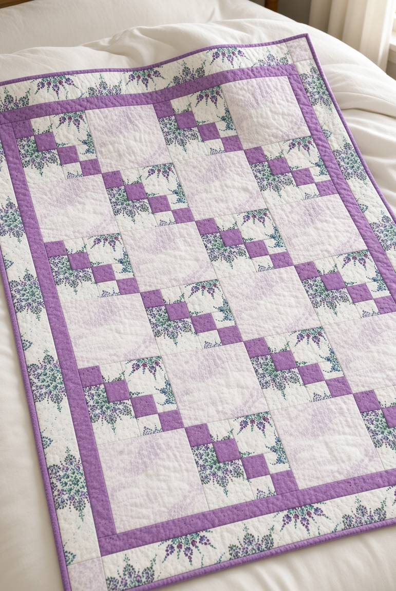 Carmon's Quilt Shop Dragonfly Wonder lavender quilt featuring geometric blocks and floral prints on a white bed.