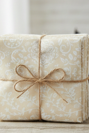 Carmon's Quilt Shop Light As Air charm pack of 5-inch cotton fabric squares with cream floral and botanical prints.