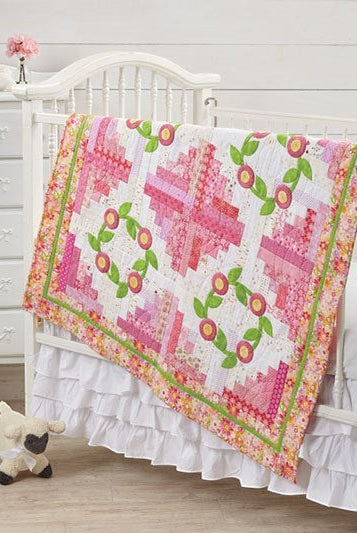 Carmon's Quilt Shop Log Cabin Variations quilt pattern featuring pink floral blocks on a white crib