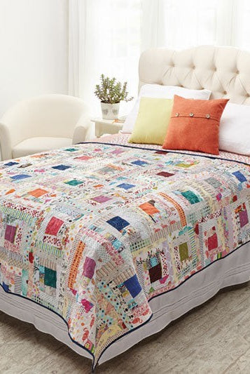 Carmon's Quilt Shop Log Cabin Variations quilt pattern book featuring a colorful patchwork quilt on a bed