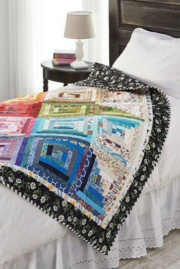 Carmon's Quilt Shop Log Cabin Variations quilt pattern book featuring a colorful patchwork quilt on a bed