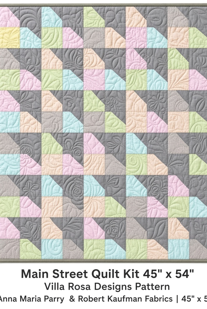 Carmon's Quilt Shop Main Street quilt kit featuring pastel patchwork squares and grey floral quilting on a 45x54 throw