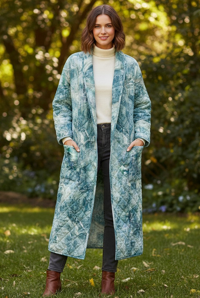 Carmon's Quilt Shop model wearing a long quilted coat made from Northcott Smooth Sailing marble pattern teal fabric