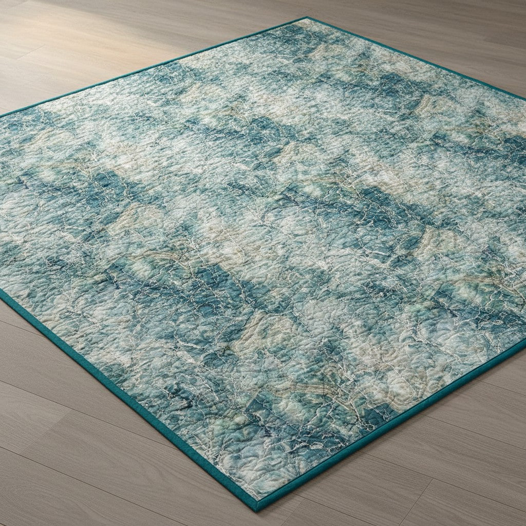 Carmon's Quilt Shop Northcott Smooth Sailing marble pattern quilt fabric in teal, blue, and white on a wood floor.