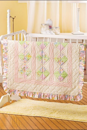 Carmon's Quilt Shop baby quilt featuring pastel patchwork squares, ruffled edges, and heart-patterned quilting.