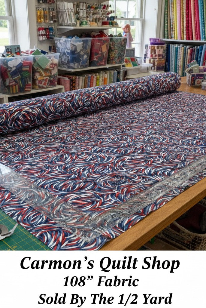 Carmon's Quilt Shop patriotic swirl 108-inch wide cotton quilt backing fabric in red, white, and blue on a cutting table
