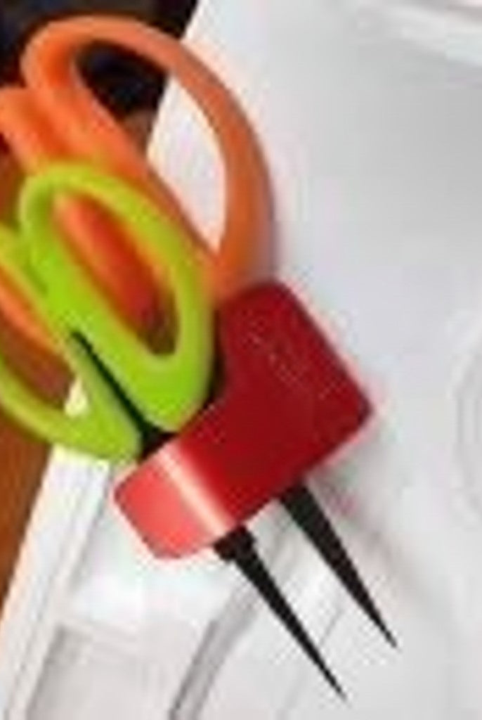 Carmon's Quilt Shop red Sew Very Smooth scissor holster holding orange and green scissors on a sewing machine