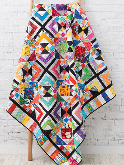 Carmon's Quilt Shop Scrap-Happy quilt featuring colorful geometric patterns and black and white fabric accents