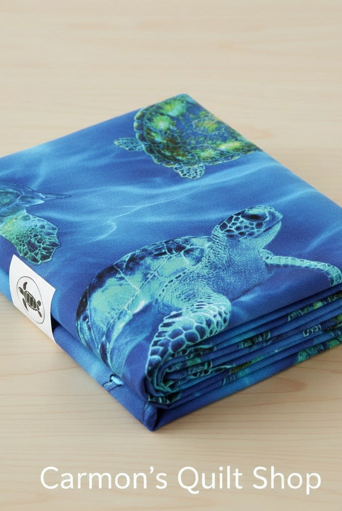 Carmon's Quilt Shop 108-inch wide blue cotton quilting fabric featuring a detailed sea turtle underwater print.