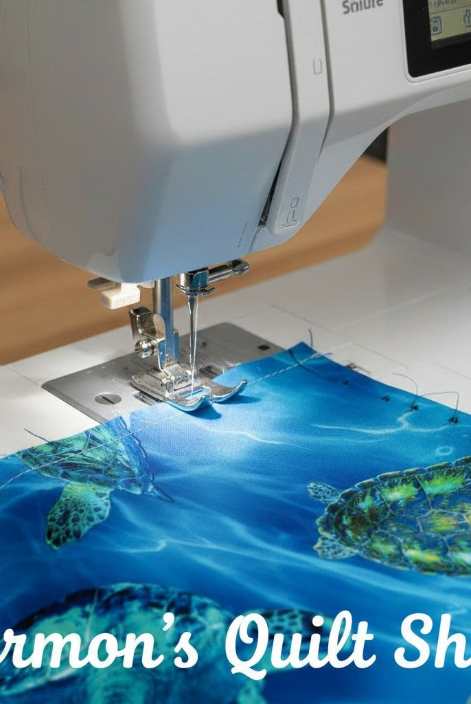 Carmon's Quilt Shop sea turtle patterned 108 inch wide cotton quilting fabric being sewn on a white sewing machine.