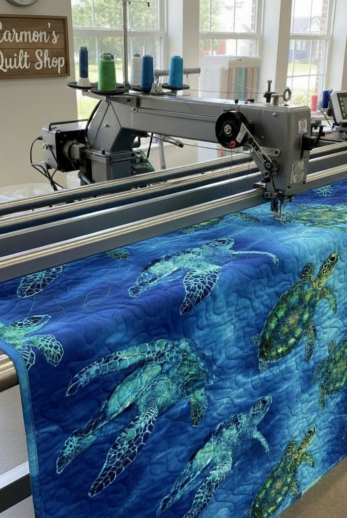 Carmon's Quilt Shop sea turtle patterned 108-inch cotton fabric being machine quilted on a longarm frame