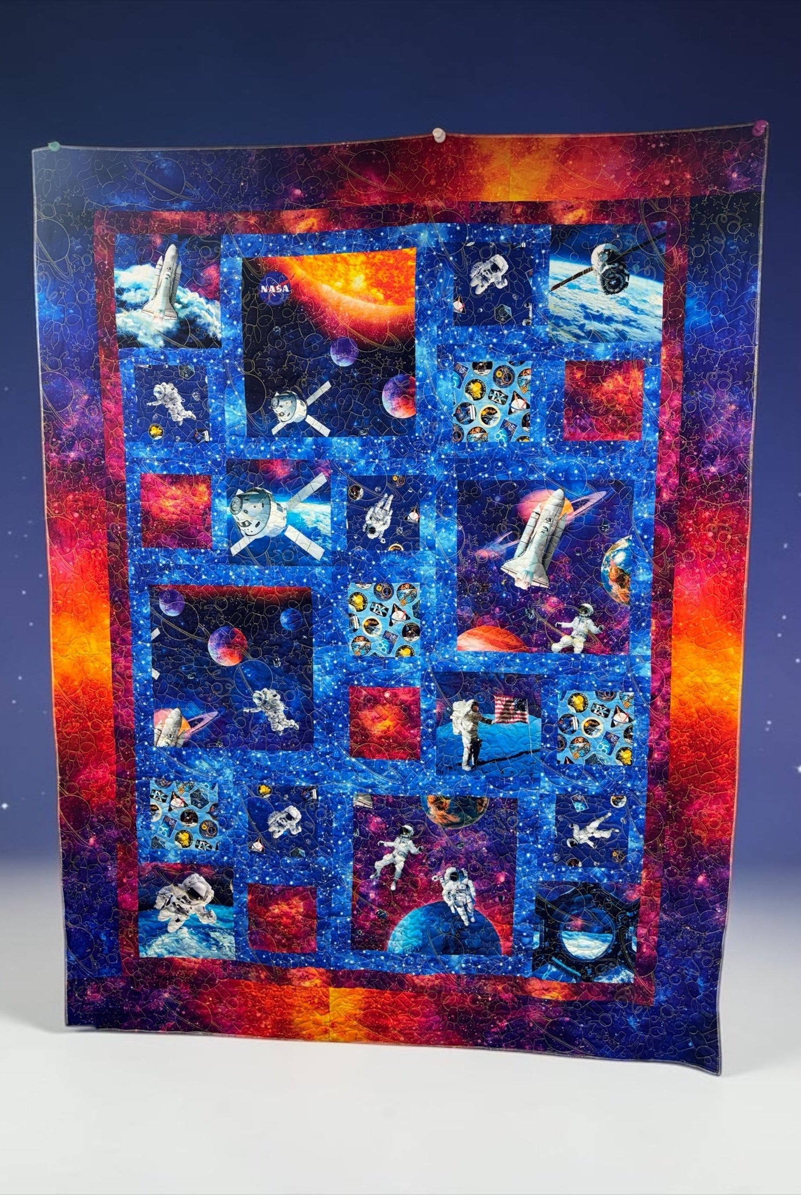 Carmon's Quilt Shop Space Odyssey Hopscotch NASA quilt kit featuring vibrant space, astronaut, and planet prints.