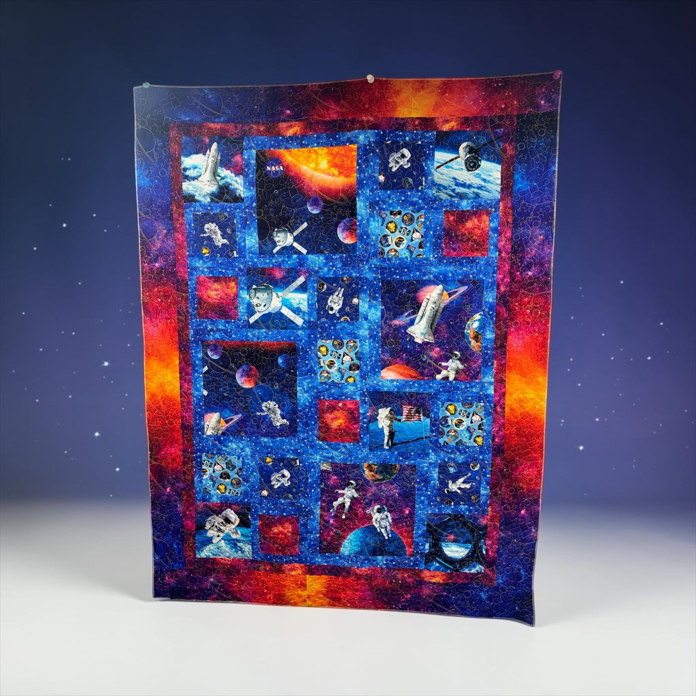 Carmon's Quilt Shop Space Odyssey Hopscotch NASA quilt kit featuring vibrant space, astronaut, and planet prints.