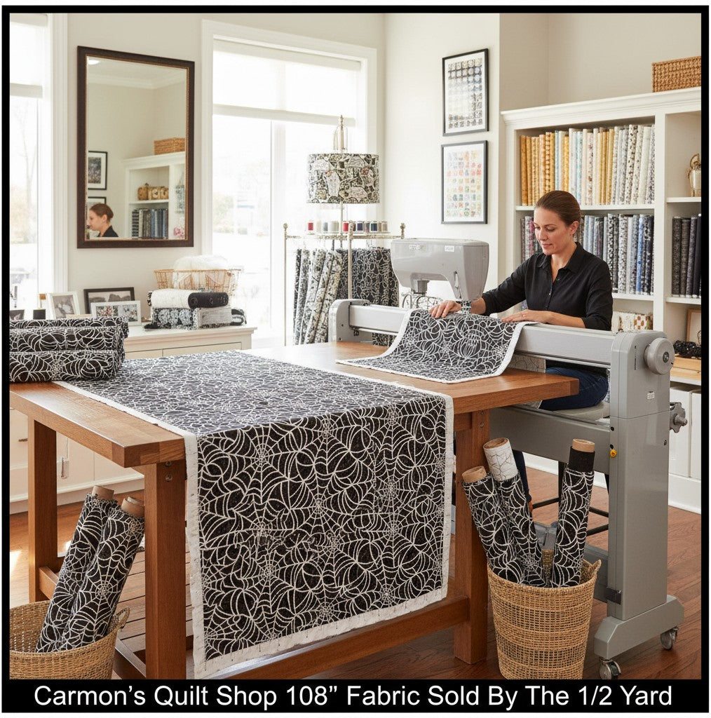Carmon's Quilt Shop black and white spiderweb print 108-inch wide cotton quilting fabric on a sewing table.