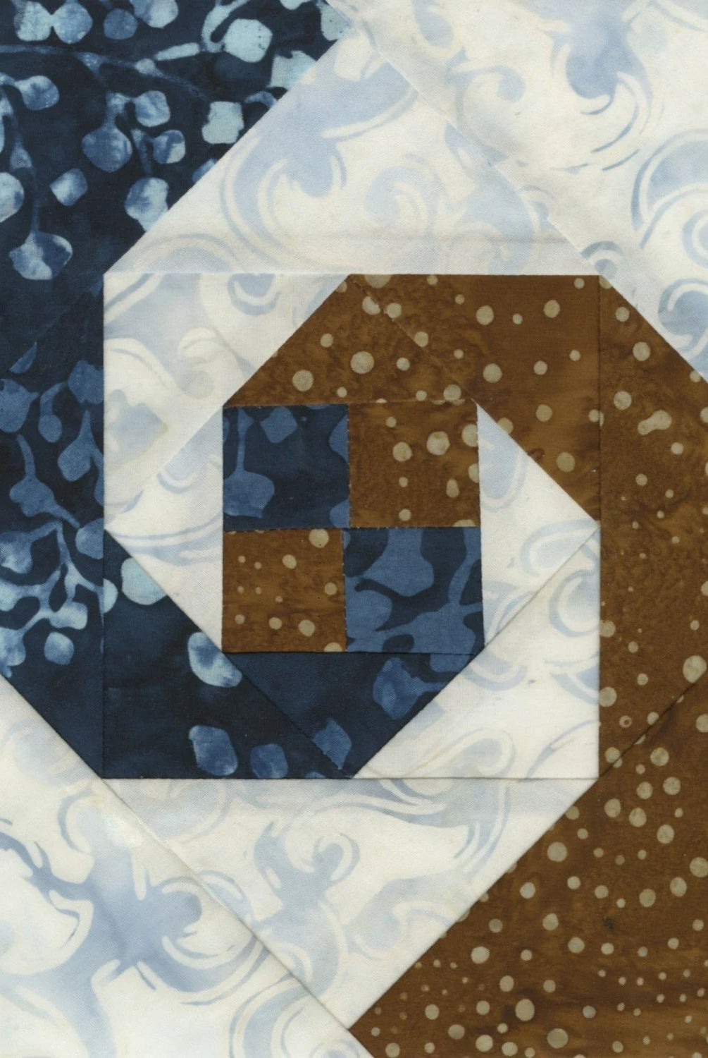 Carmon's Quilt Shop Square on Square 8-inch trim tool quilt block in blue, brown, and white fabrics.