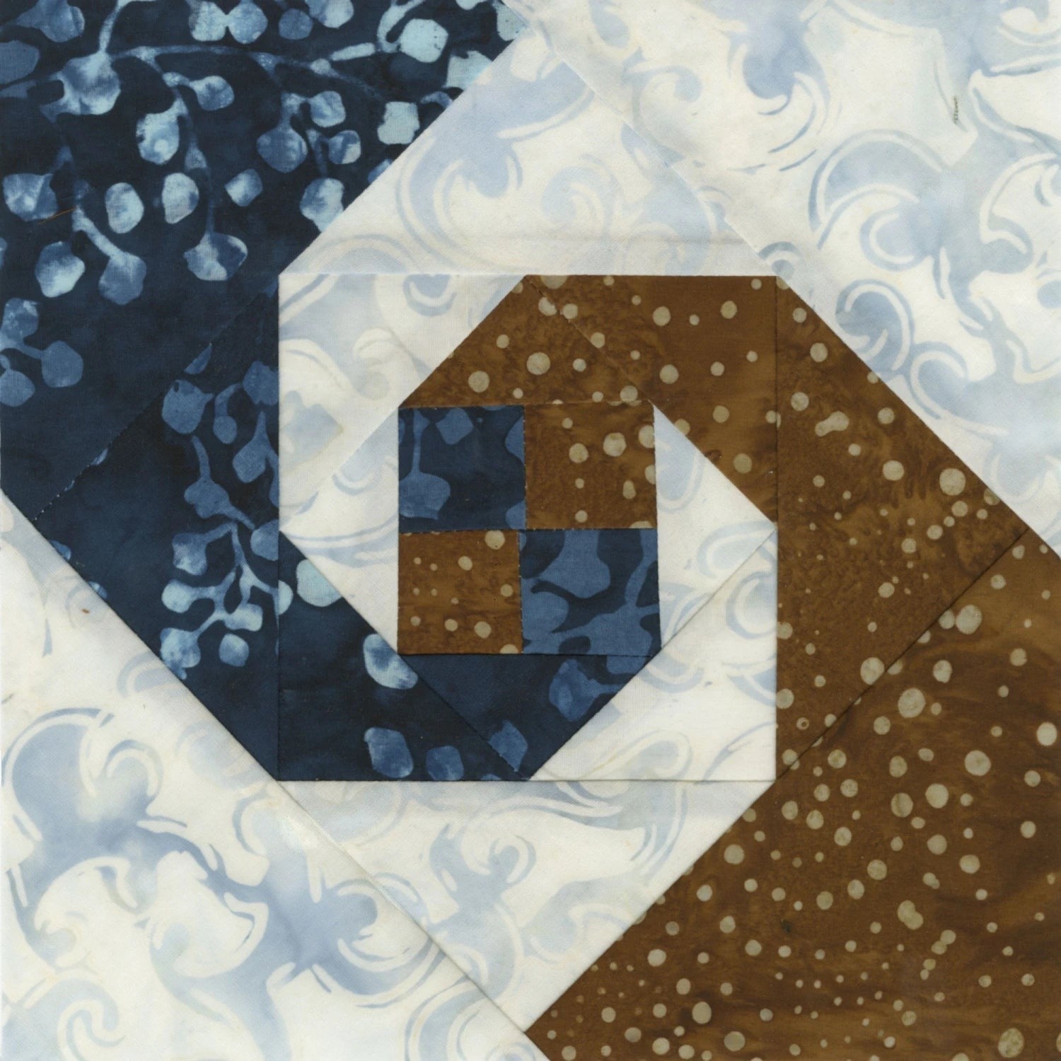 Carmon's Quilt Shop Square on Square 8-inch trim tool quilt block in blue, brown, and white fabrics.