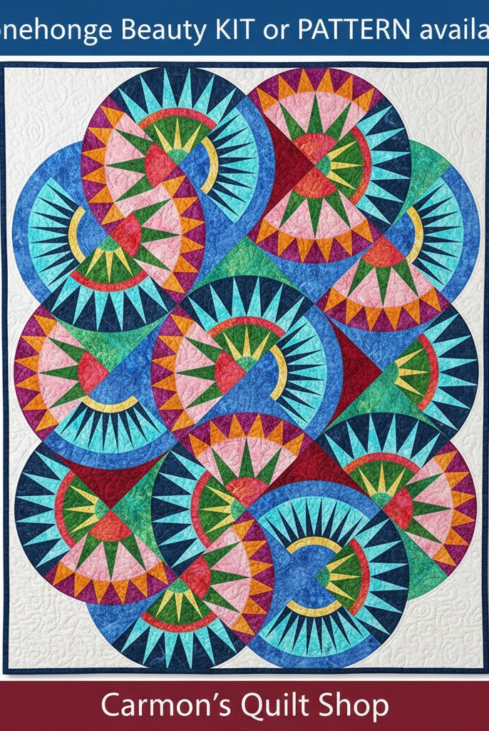 Carmon's Quilt Shop Stonehenge Beauty quilt featuring a vibrant paper-pieced star design in blue, green, and pink tones.