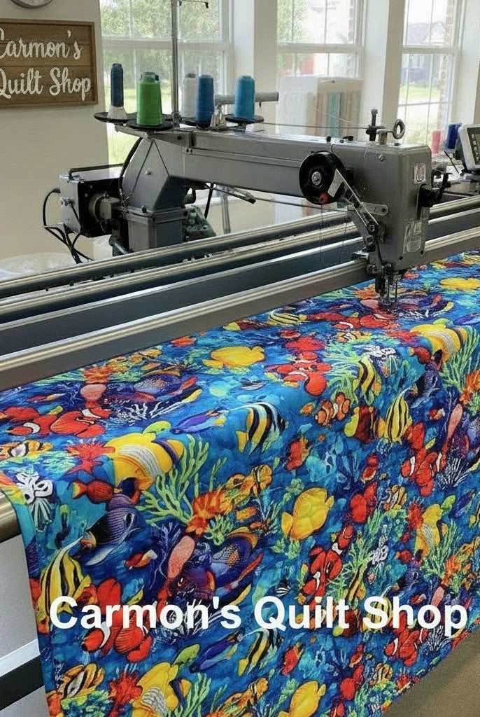 Carmon's Quilt Shop longarm machine quilting vibrant Jewel of the Sea cotton fabric with colorful tropical fish print.