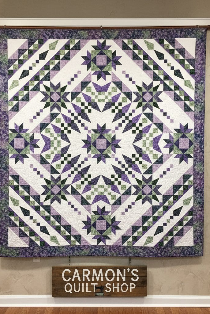 Carmon's Quilt Shop Vintner's Treasure batik quilt featuring a purple and green starburst design on a wall display.