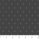 Fabric with a pattern of small white crosses on a dark gray background, with a ruler at the bottom.