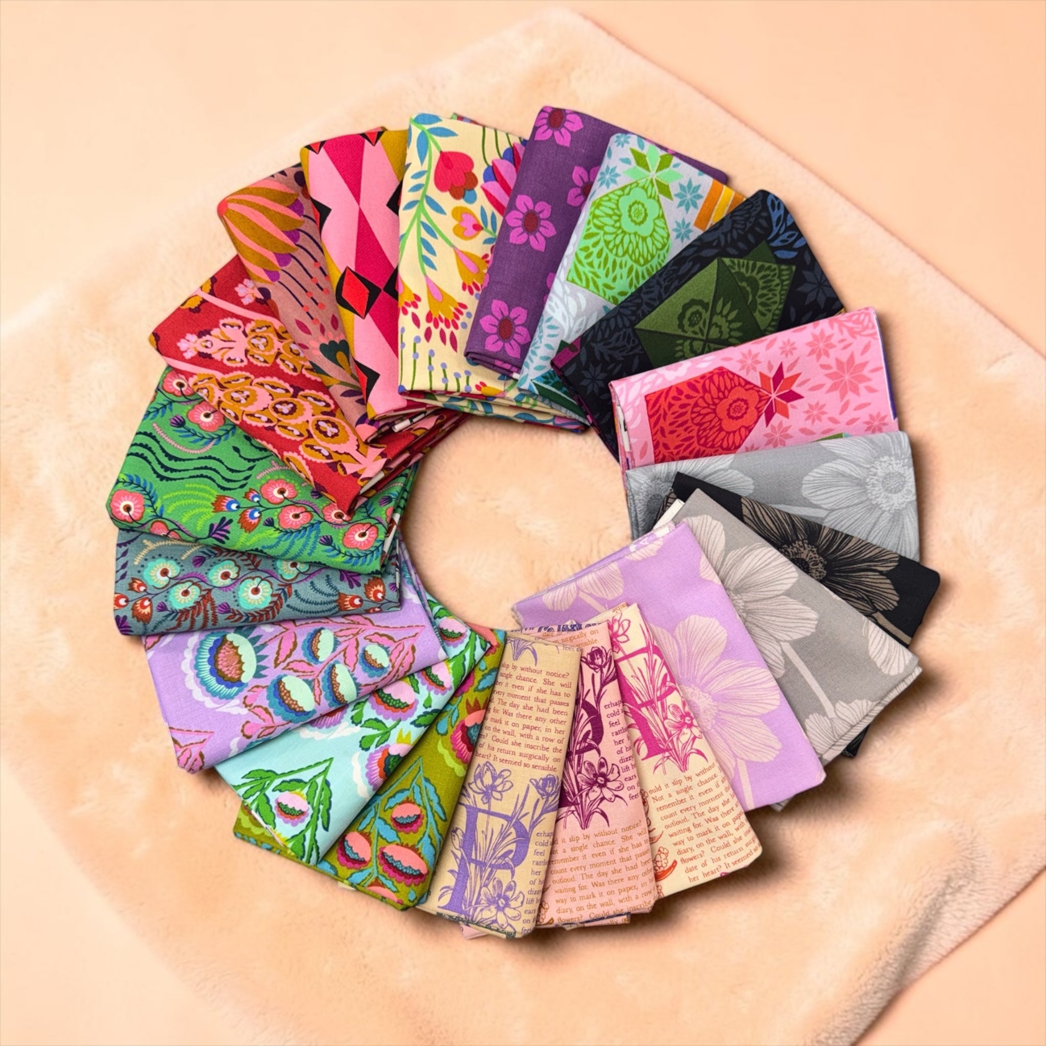 Collection of colorful fabric swatches arranged in a circular pattern on a wooden surface.