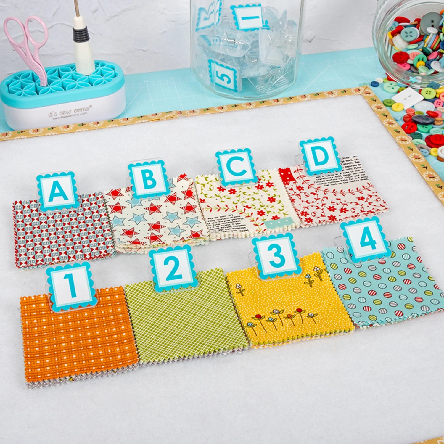 Colorful fabric swatches with letters and numbers on a white surface. Quilt Clips with letter tiles and fabric on a blue surface