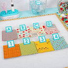 Colorful fabric swatches with letters and numbers on a white surface. Quilt Clips with letter tiles and fabric on a blue surface
