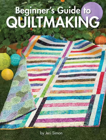 Book cover of 'Beginner's Guide to Quiltmaking' by Jeri Simon with a colorful quilt on grass.