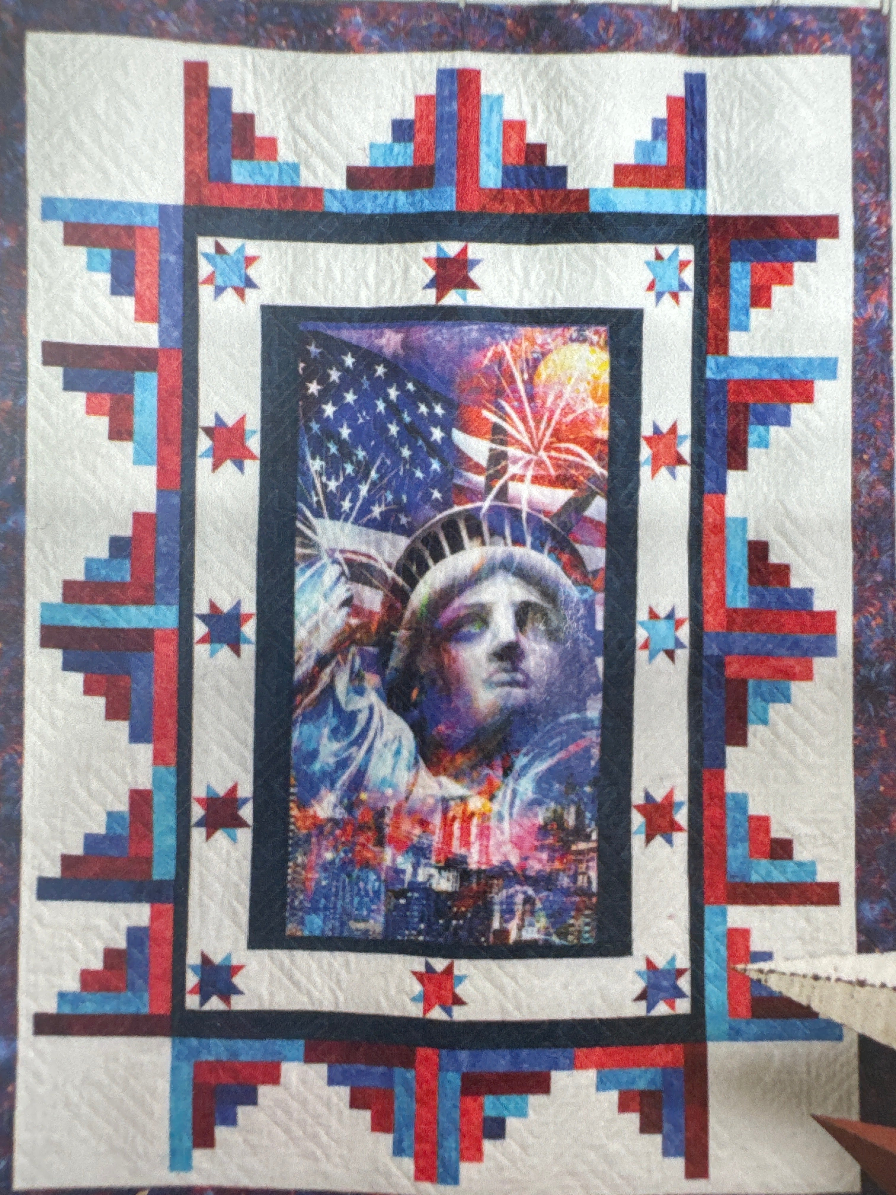 Quilt with a central portrait surrounded by decorative borders featuring stars and stripes. Building Quilts With Panels Pattern Book - 4th & Main Designs- Carmon's Quilt Shop 