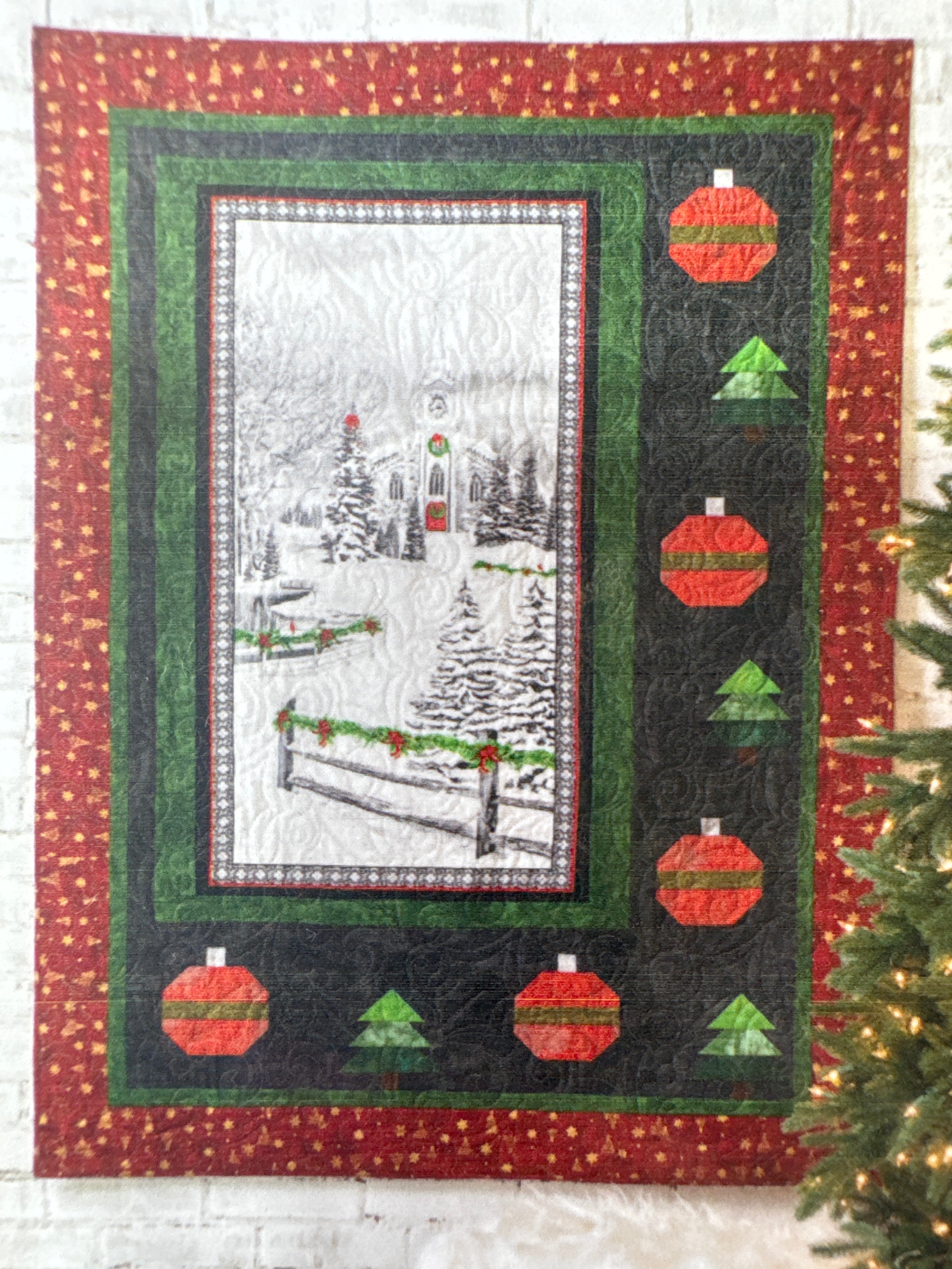 Quilt with Christmas-themed design featuring red and green ornaments on a dark green background. Building Quilts With Panels Pattern Book - 4th & Main Designs- Carmon's Quilt Shop 