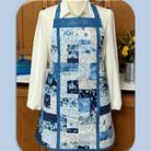 Quilted apron with charm squares design on a wooden surface