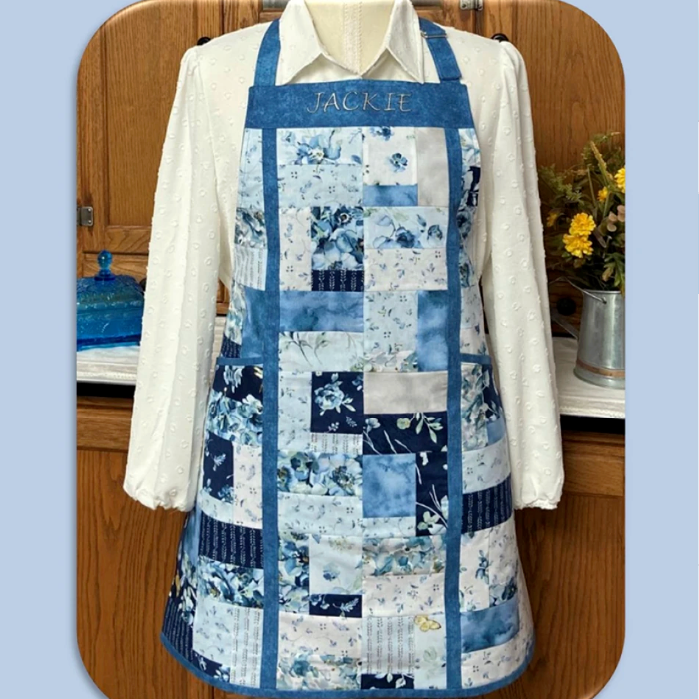 Quilted apron with charm squares design on a wooden surface